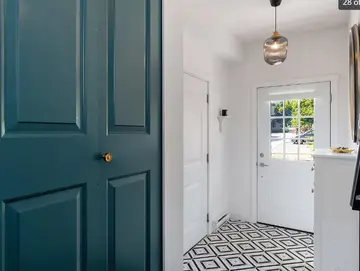 Entryway by PS Tiling, photo from a Google review: black and white patterned floor tile beside teal doors, finished.