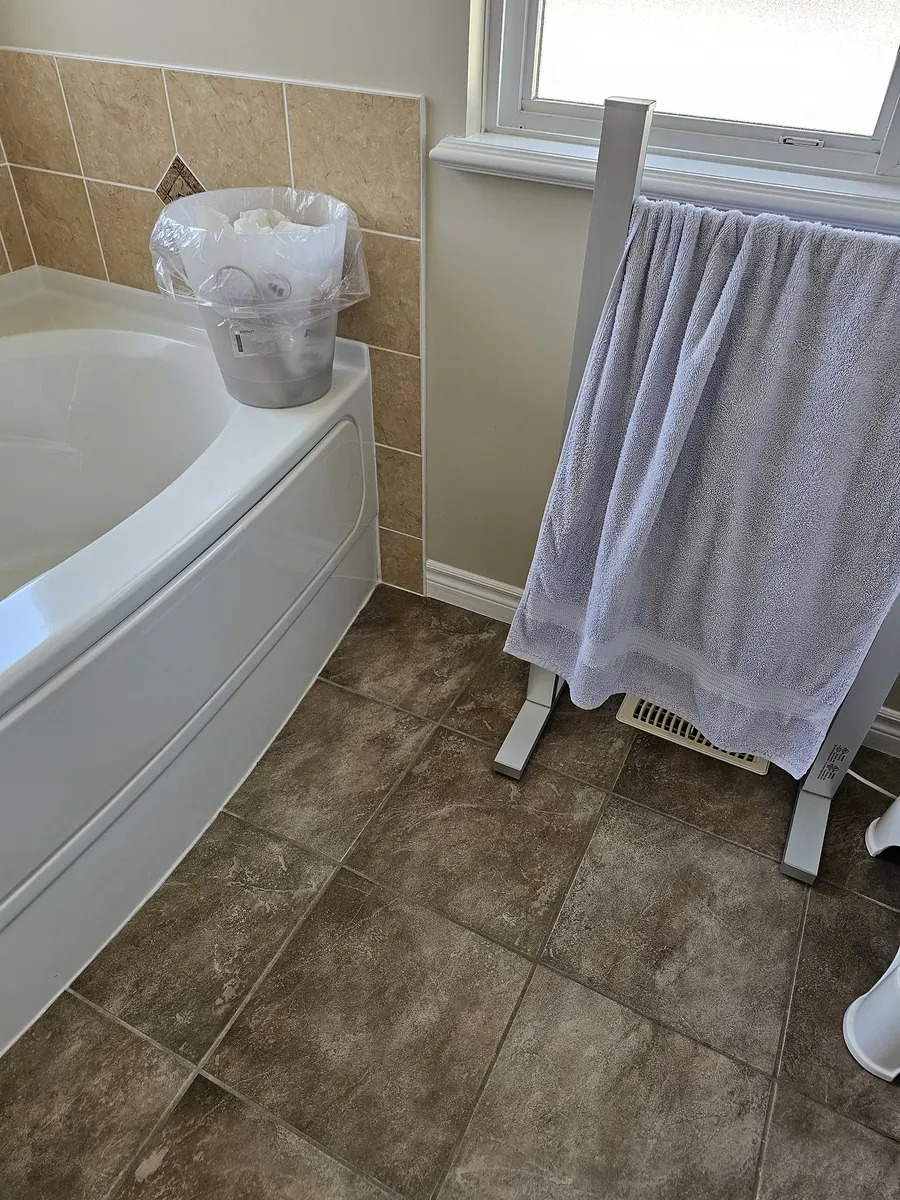 Bathroom renovation in Port Coquitlam by PS Tiling: the old corner tub and beige wall tile, before.