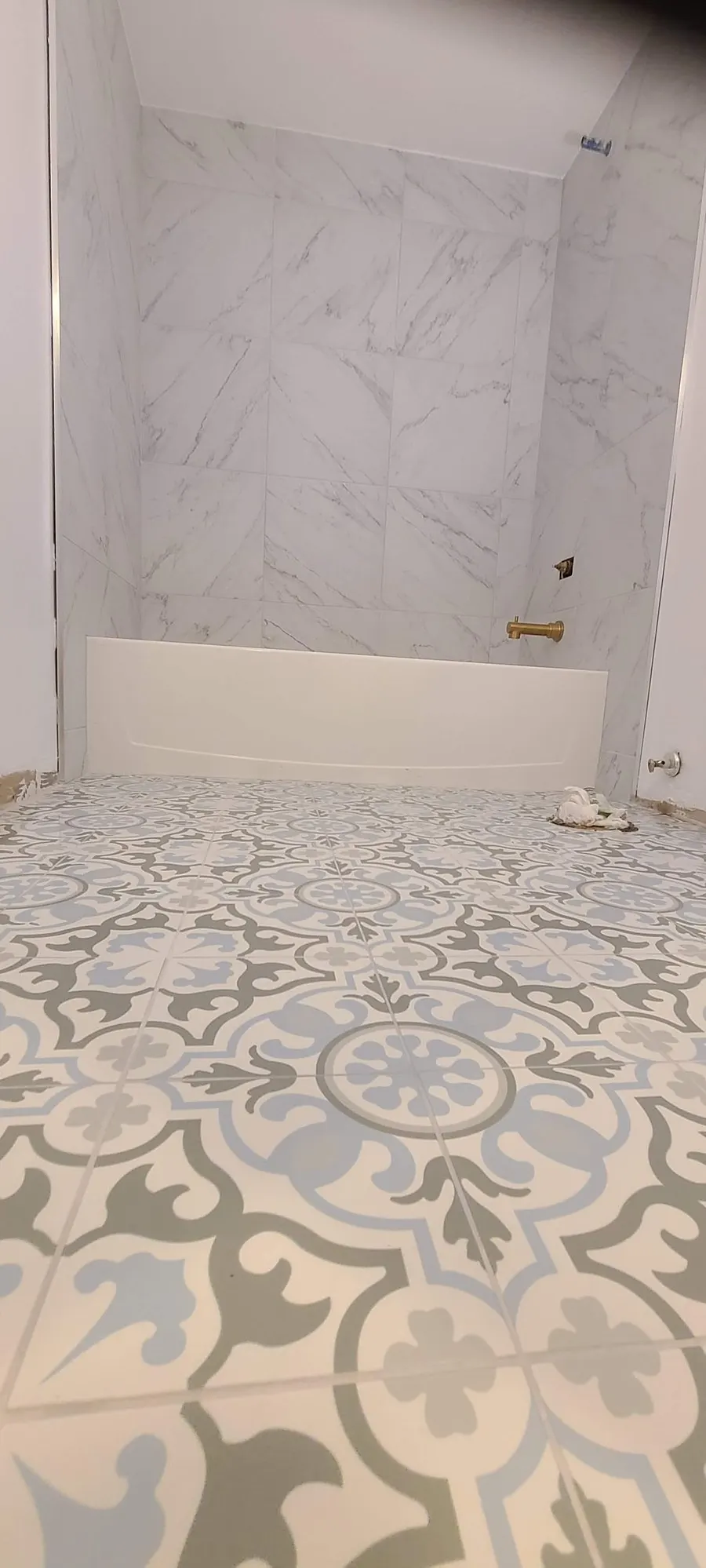 Condo bathroom renovation in Fairview, Vancouver by PS Tiling: blue-grey patterned floor with marble-look tub surround, finished.