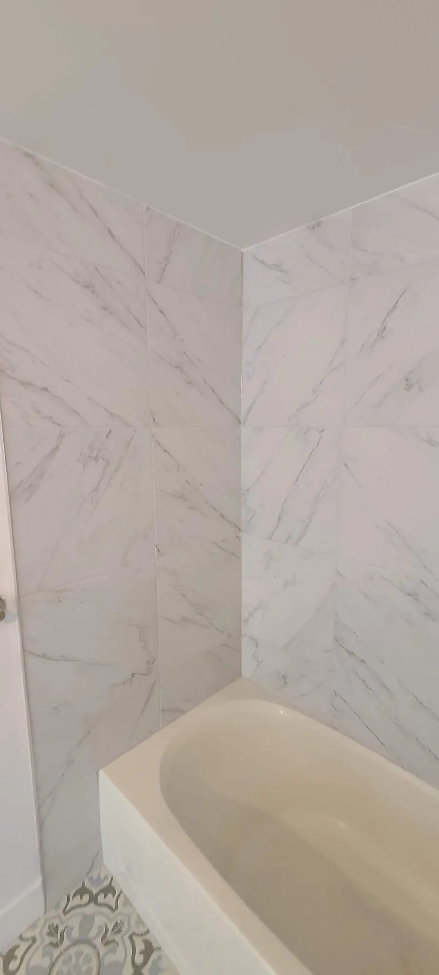 Condo bathroom renovation in Fairview, Vancouver by PS Tiling: marble-look porcelain wall tile, detail.