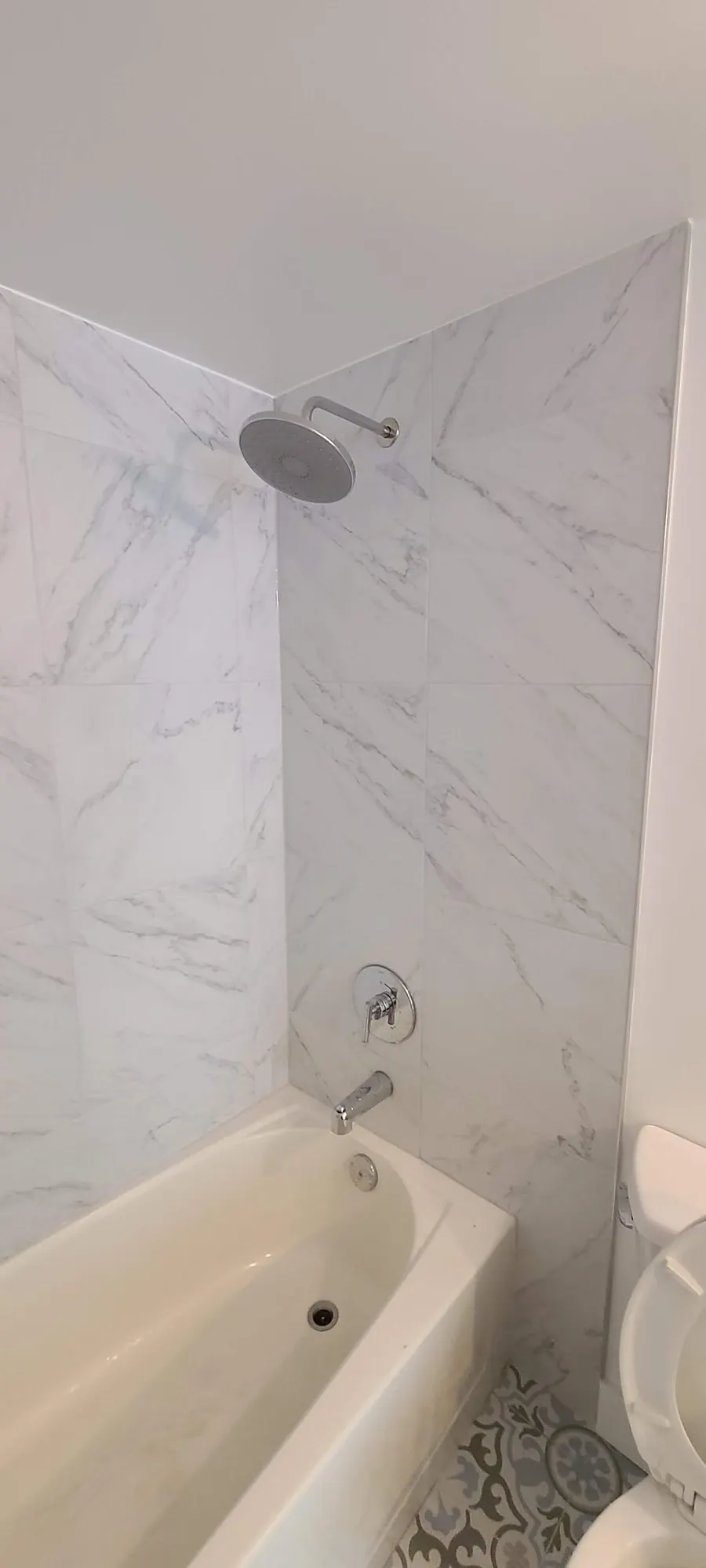 Condo bathroom renovation in Fairview, Vancouver by PS Tiling: marble-look tub surround with chrome fixtures, finished.