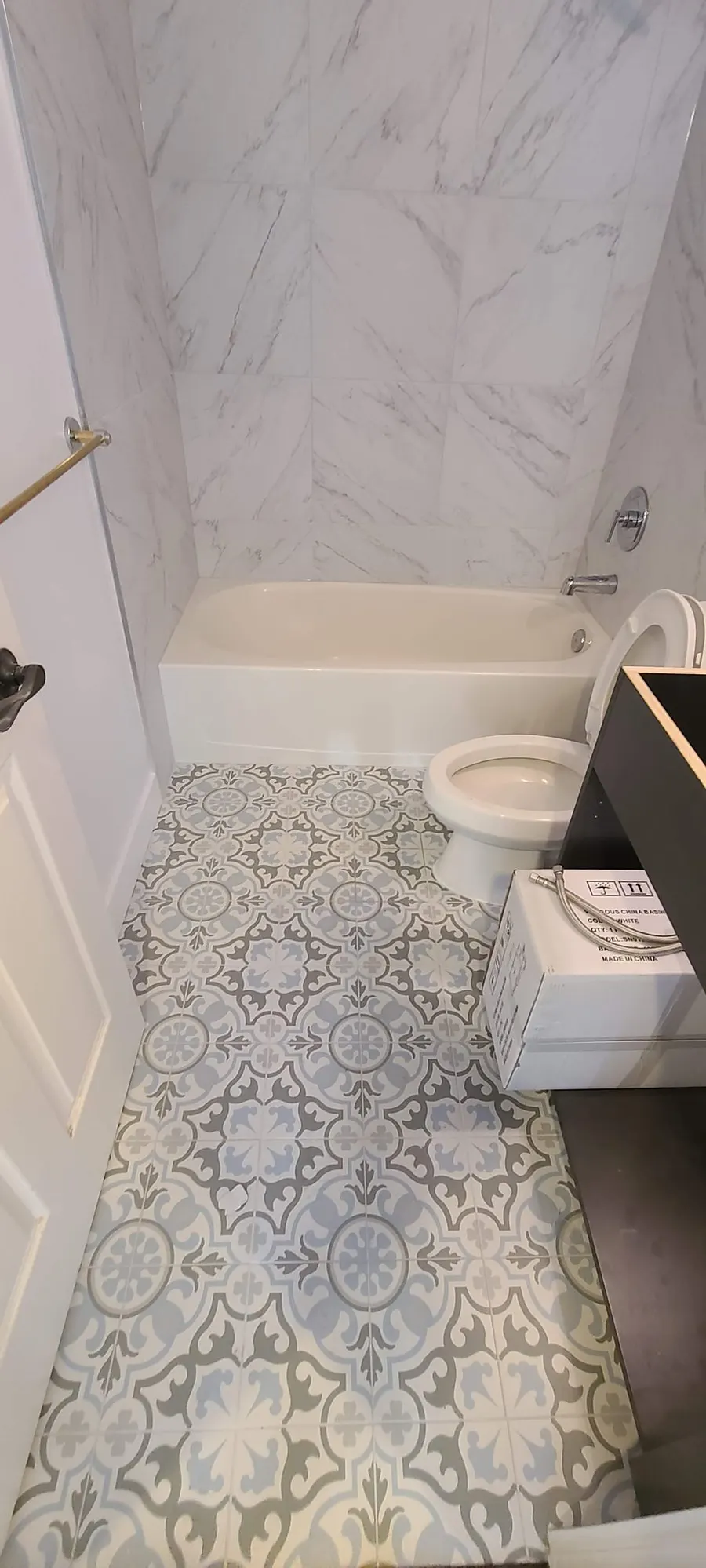 Condo bathroom renovation in Fairview, Vancouver by PS Tiling: second bathroom overview with marble-look walls and blue patterned floor, finished.