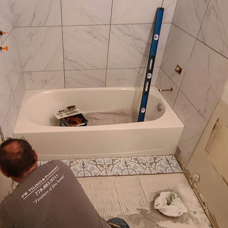 Condo bathroom renovation in Fairview, Vancouver by PS Tiling: tub surround tiled to the ceiling, grout pending.