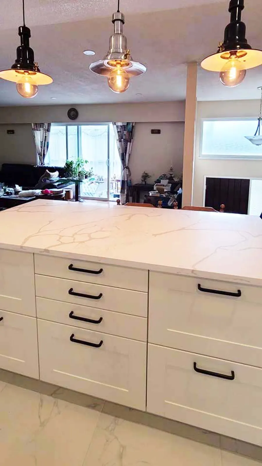 Kitchen renovation in Port Moody by PS Tiling: three pendant lights over the island with drawers, finished.