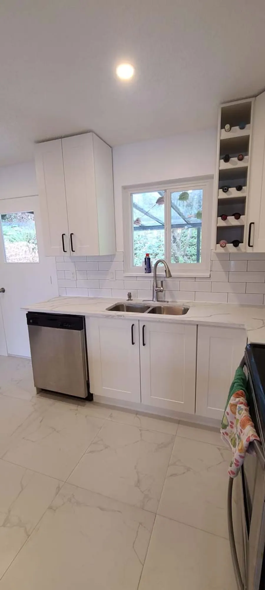 Kitchen renovation in Port Moody by PS Tiling: sink wall with dishwasher and subway backsplash, finished.