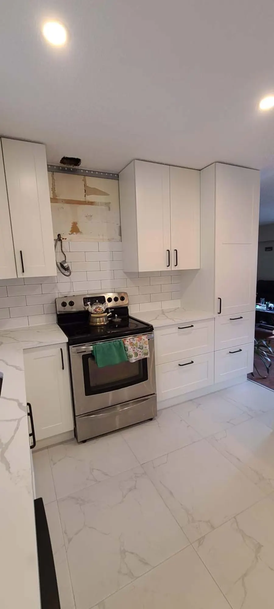 Kitchen renovation in Port Moody by PS Tiling: stainless range with white subway-tile backsplash, finished.