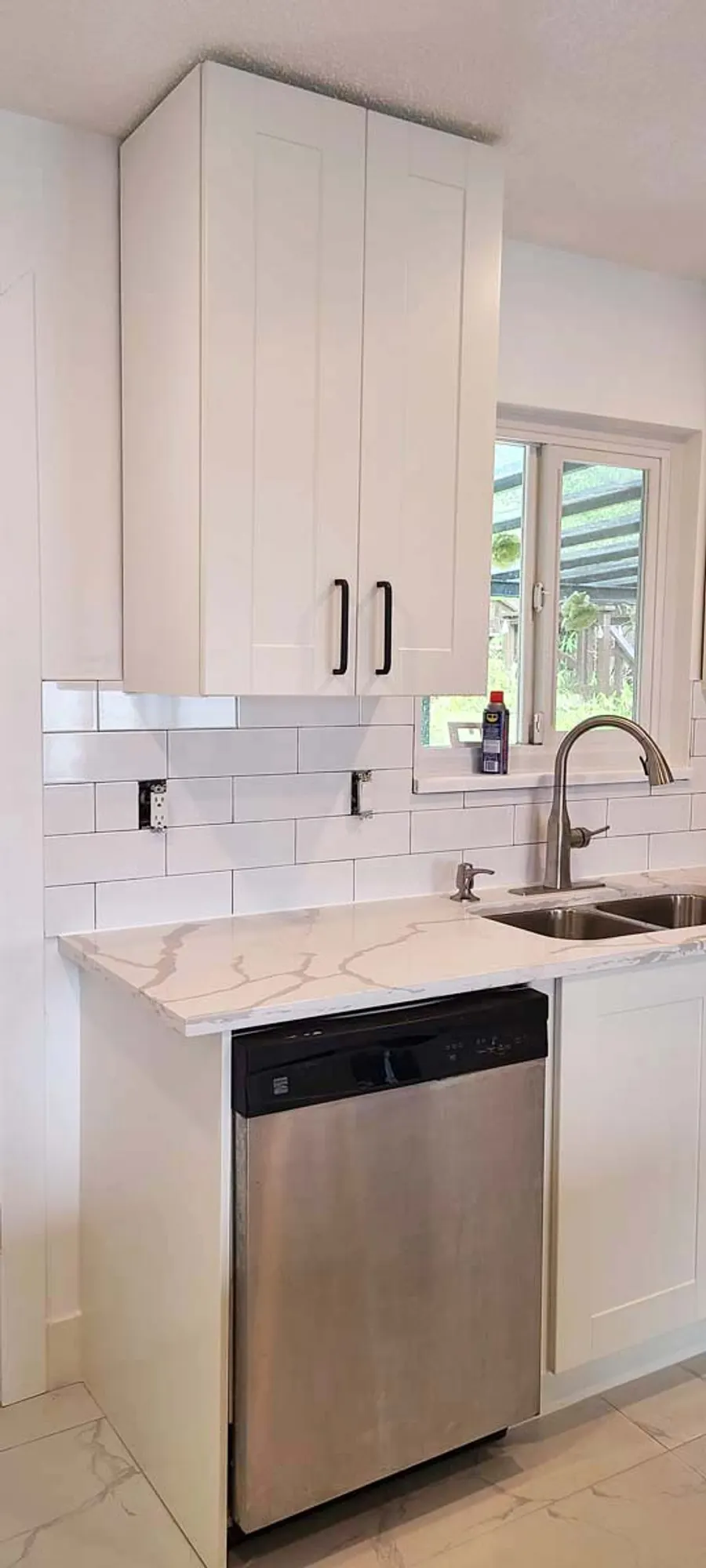 Kitchen renovation in Port Moody by PS Tiling: white shaker cabinets, white quartz counter and subway-tile backsplash by the window, finished.