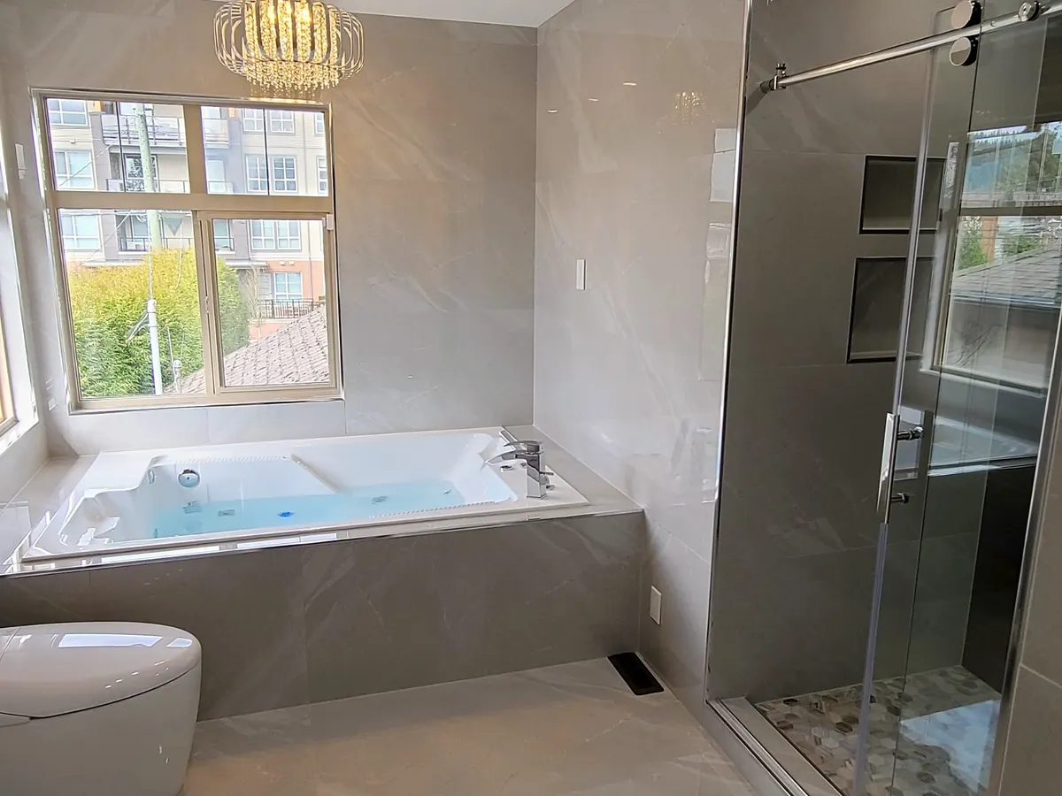 Master bathroom renovation in Burquitlam, Coquitlam by PS Tiling: jacuzzi tub and the glass shower corner with chrome fixtures, finished.