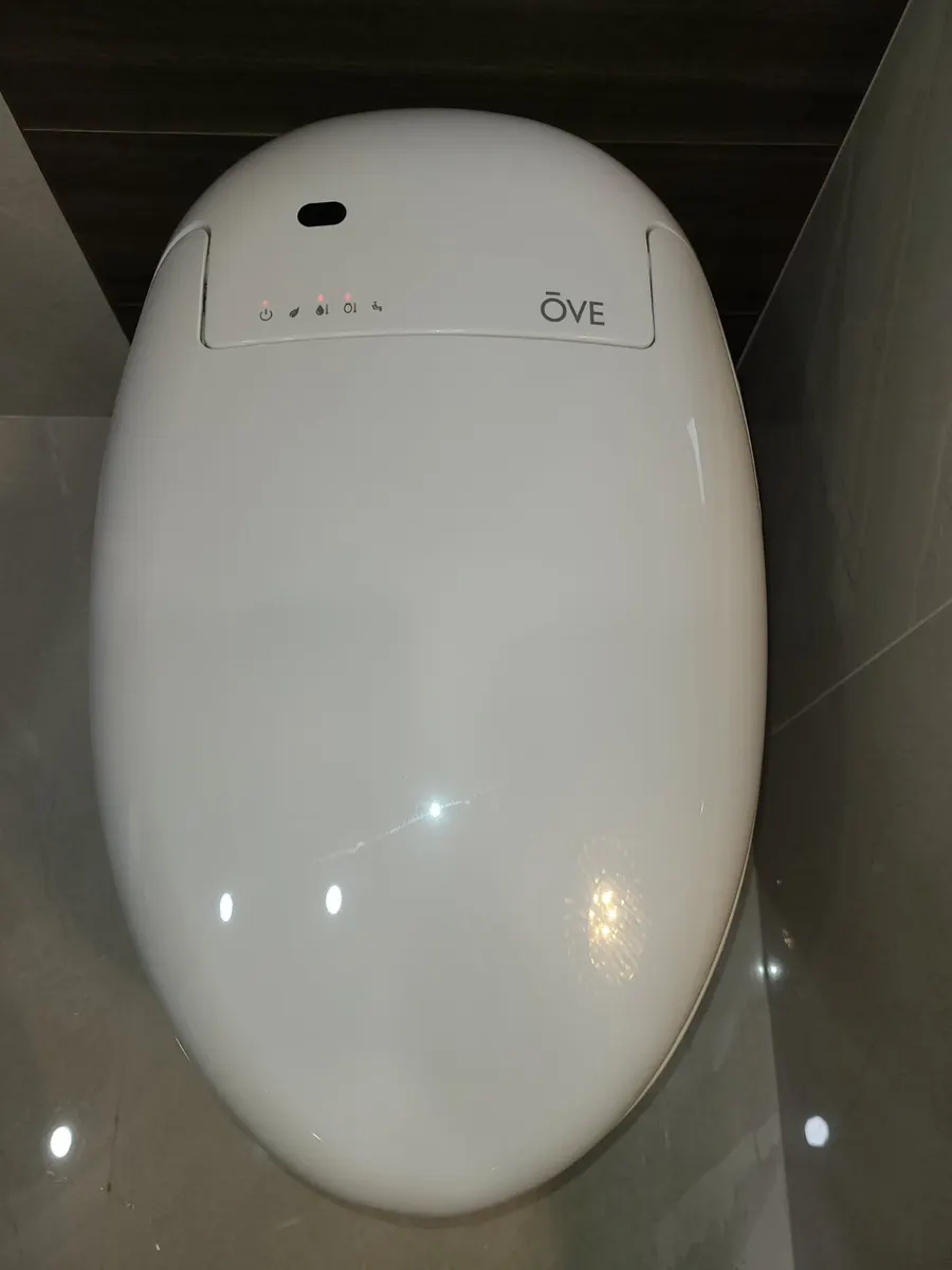 Master bathroom renovation in Burquitlam, Coquitlam by PS Tiling: ÖVE smart toilet lid against the tiled wall, detail.