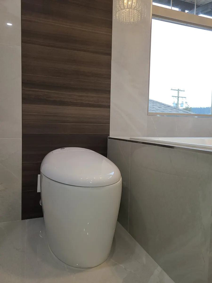 Master bathroom renovation in Burquitlam, Coquitlam by PS Tiling: smart toilet on large-format marble-look porcelain floor, finished.